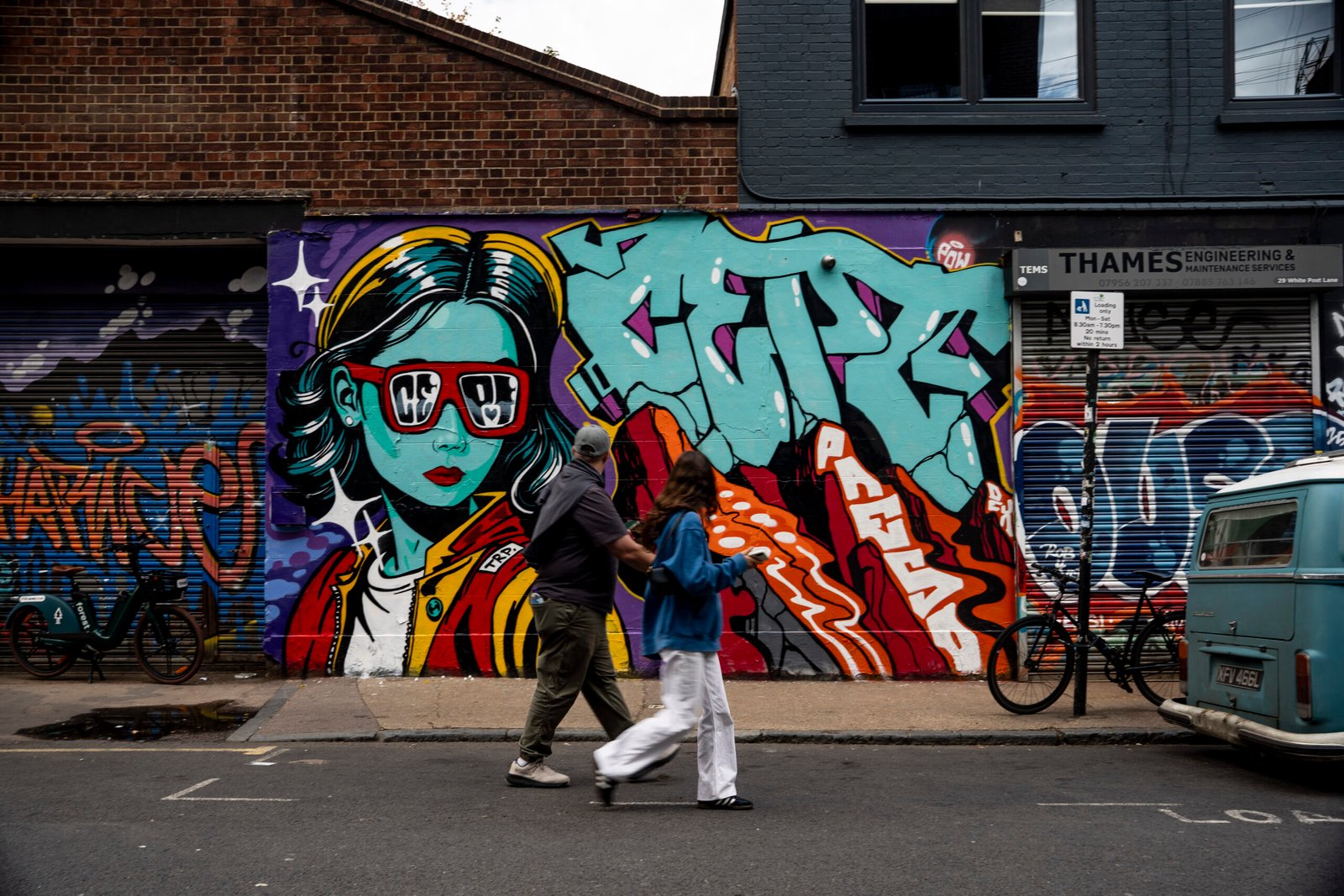 CEPT mural with a woman in red sunglasses and turquoise graffiti lettering on White Post Lane in London.